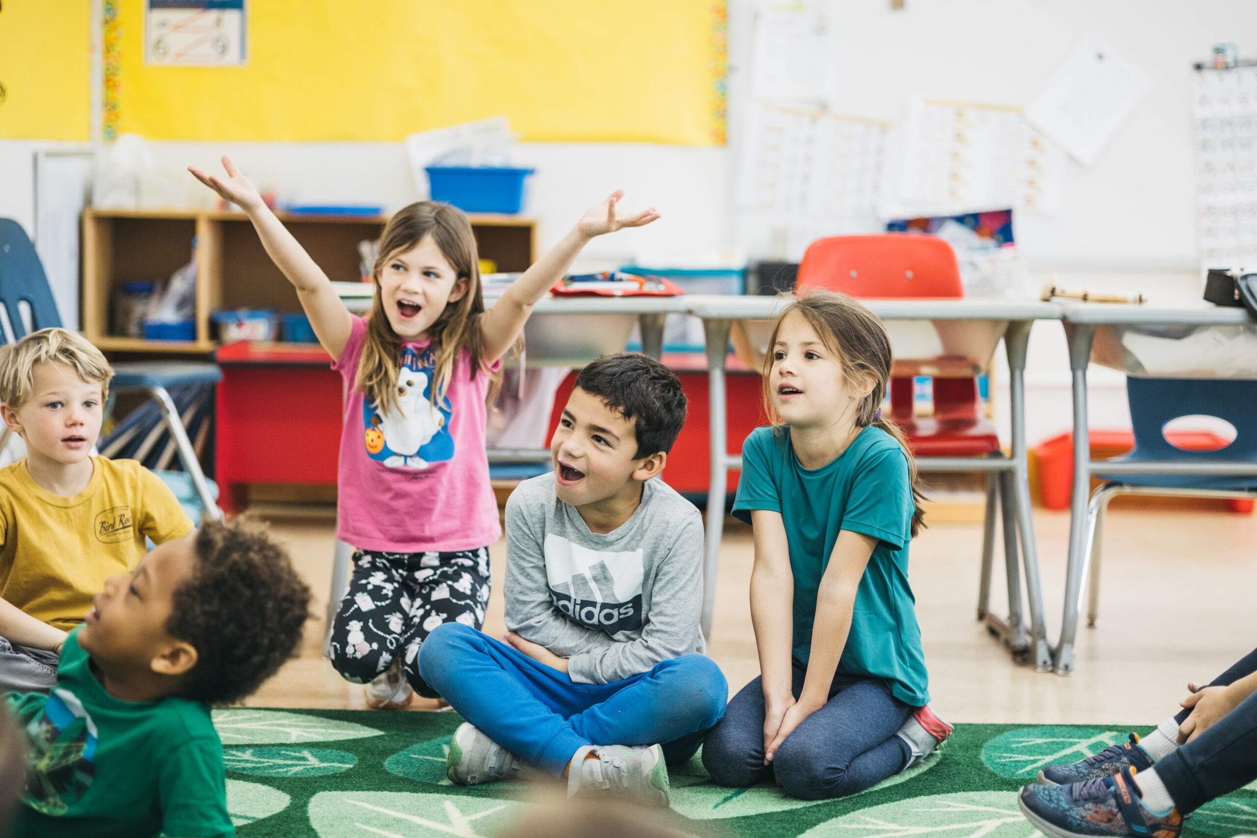 children sitting on a classroom rug